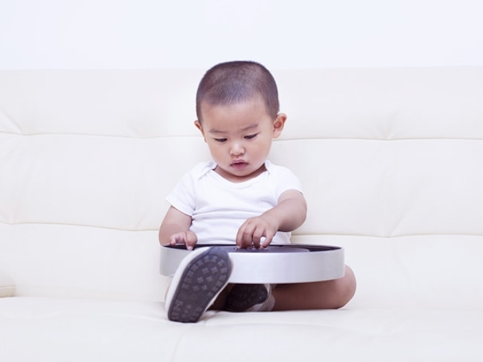 Child playing with a clock containing button batteries